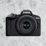 Canon R50 24.2 MP mirrorless camera body in black, refurbished model, front view showing RF/RF‑S lens mount.